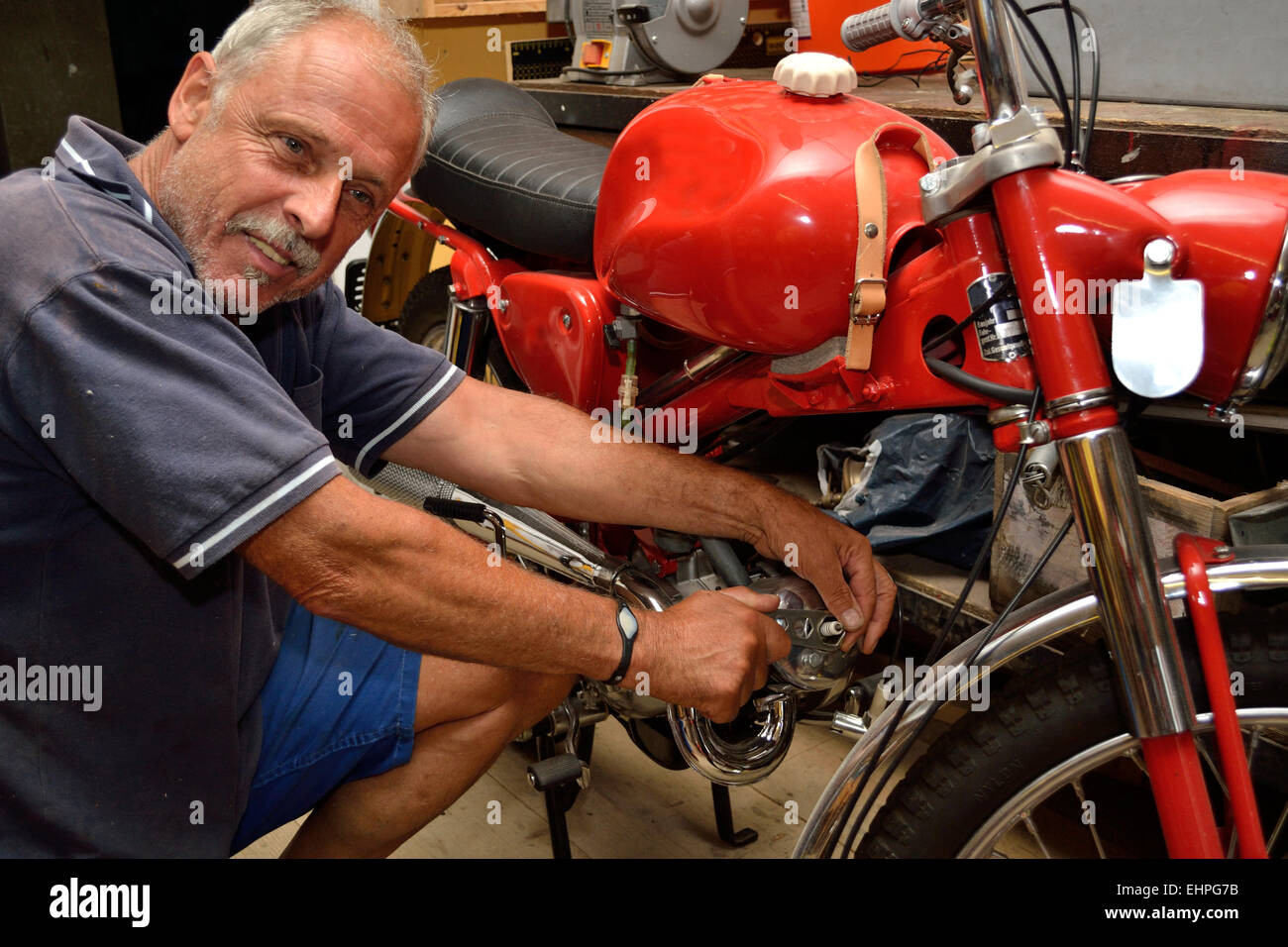 Mechanic repairs moped Stock Photo