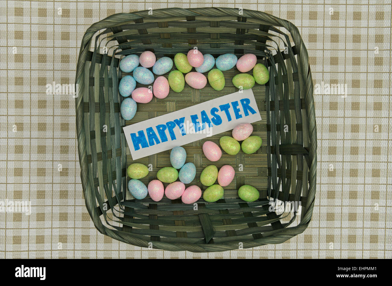 Easter eggs in basket with note on table Stock Photo