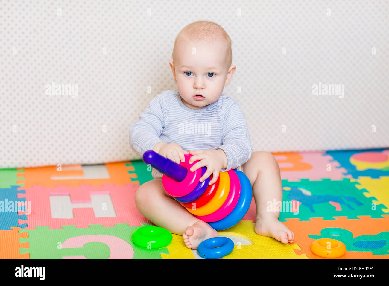 Cute little baby playing with colorful toys at home Stock Photo - Alamy
