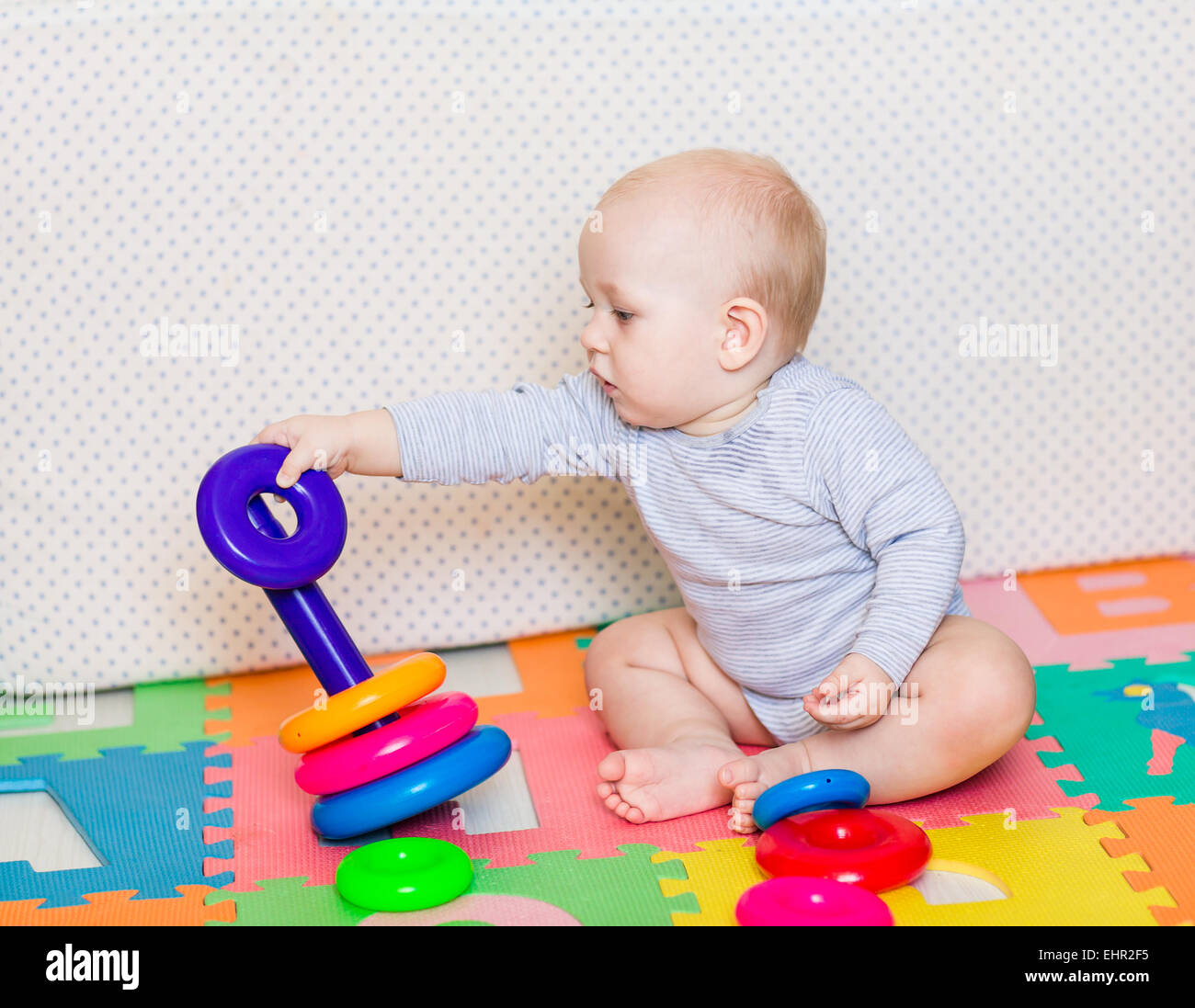 Cute little baby playing with colorful toys at home Stock Photo - Alamy