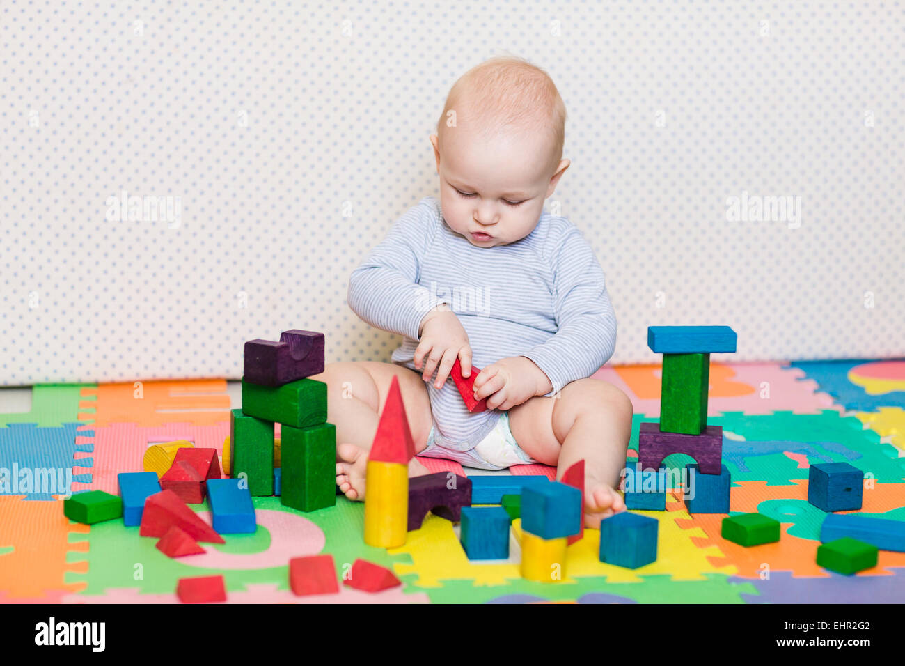 Cute little baby playing with colorful toys at home Stock Photo - Alamy