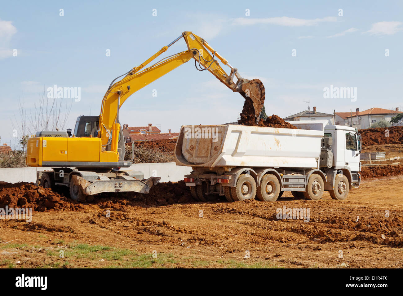 industrial excavator loading tipper truck on construction site Stock Photo