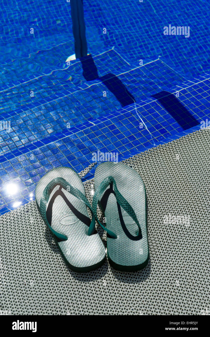 Green flip-flops at a pool Stock Photo