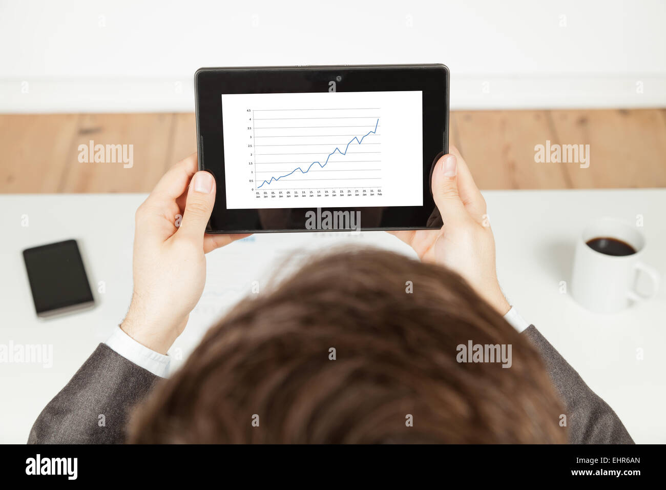 man holding tablet with increasing chart on tablet Stock Photo Alamy