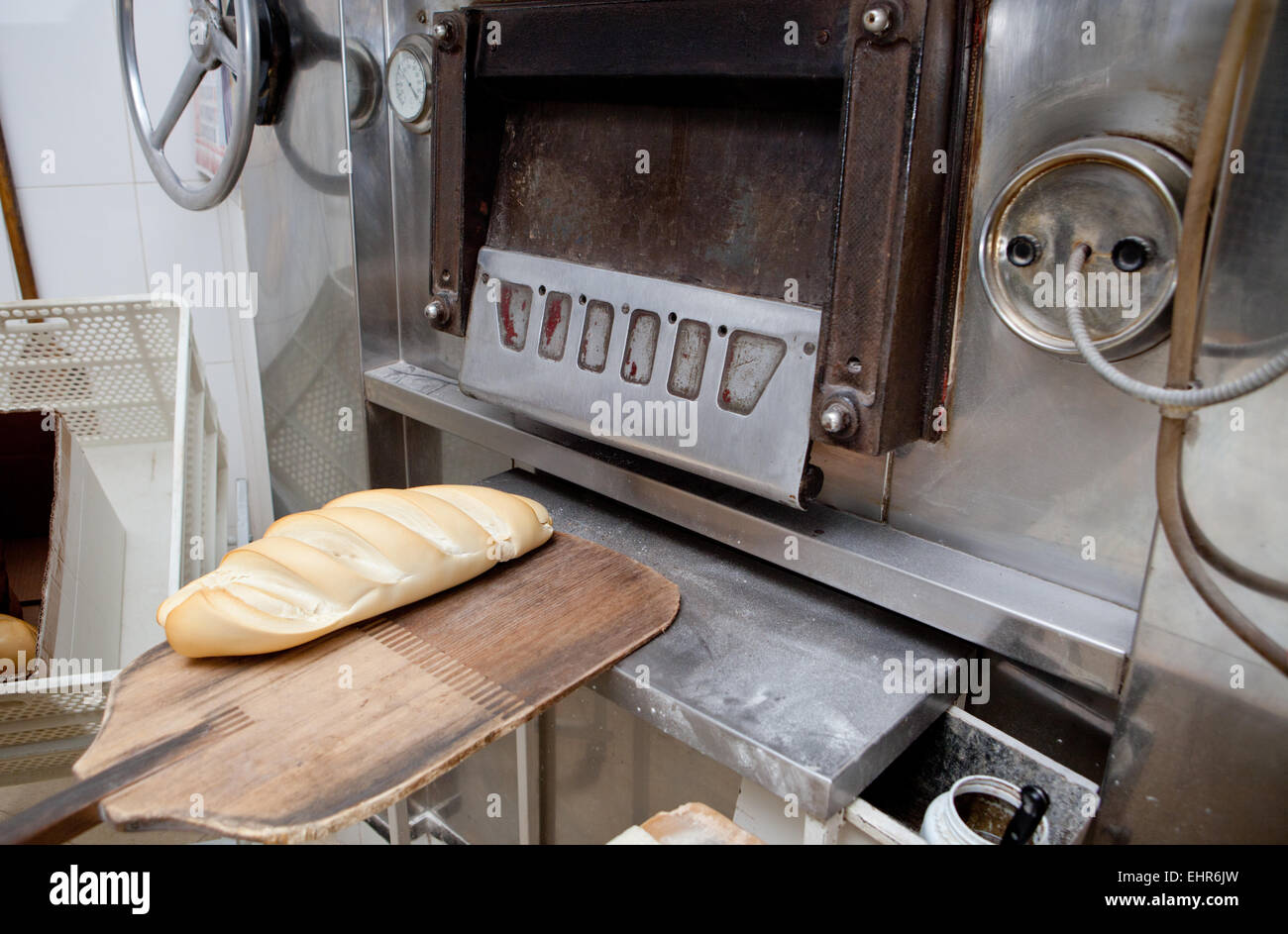 baking peel taking fresh baked bread from oven. Manufacturing process