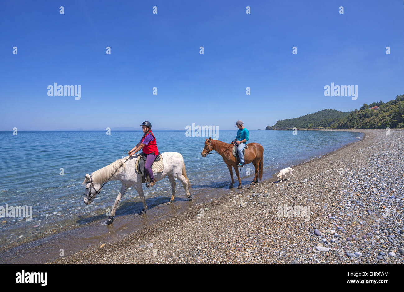 Horse riding at Psaropouli beach in the northeastern Evia, Aegean sea, Greece Stock Photo
