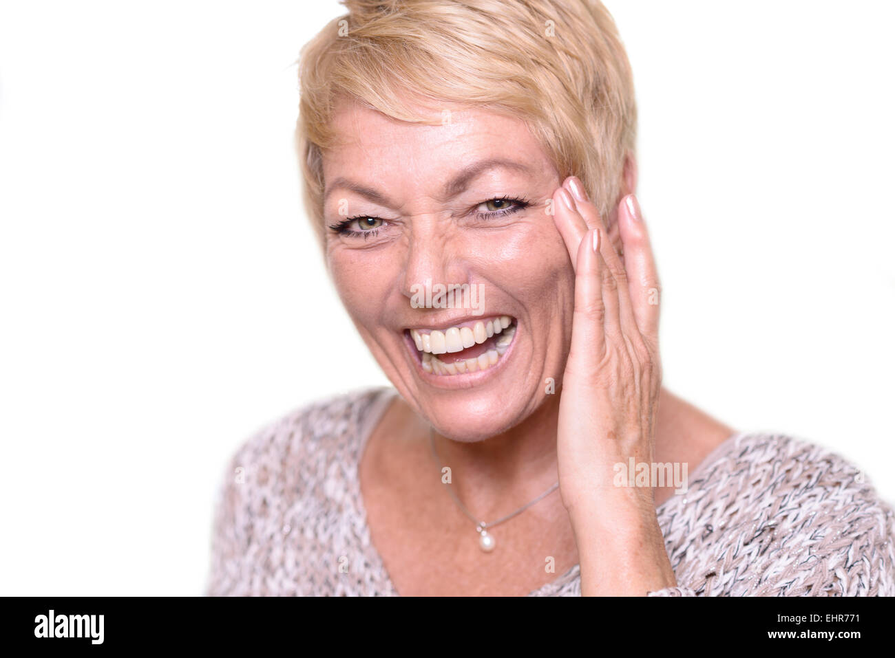 Close up Happy Middle Age Woman, with Short Blond Hair, Laughing While Touching her Face and Looking at the Camera. Stock Photo