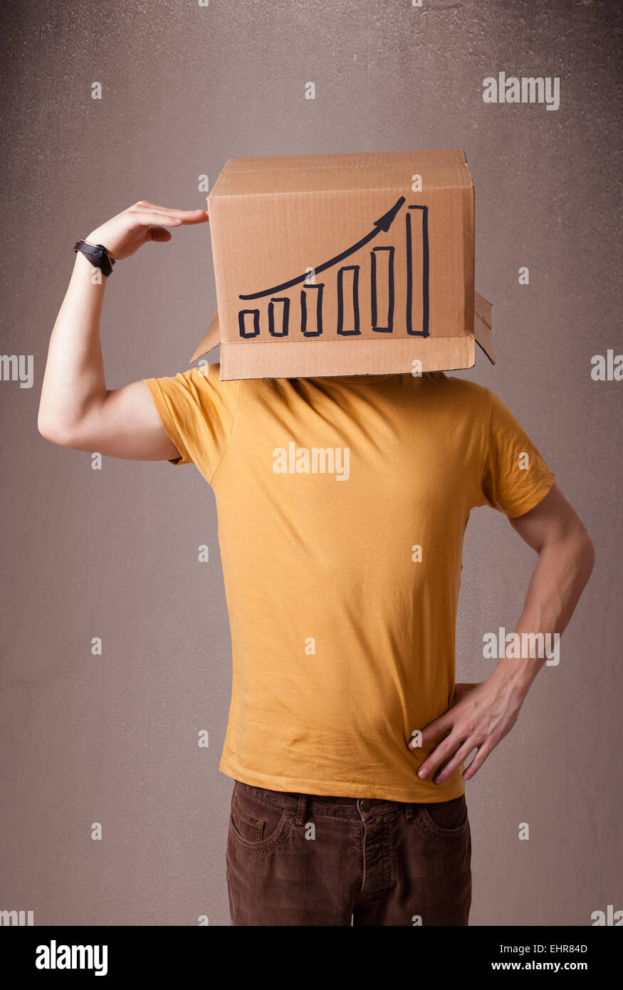 Young man gesturing with a cardboard box on his head with diagram Stock Photo