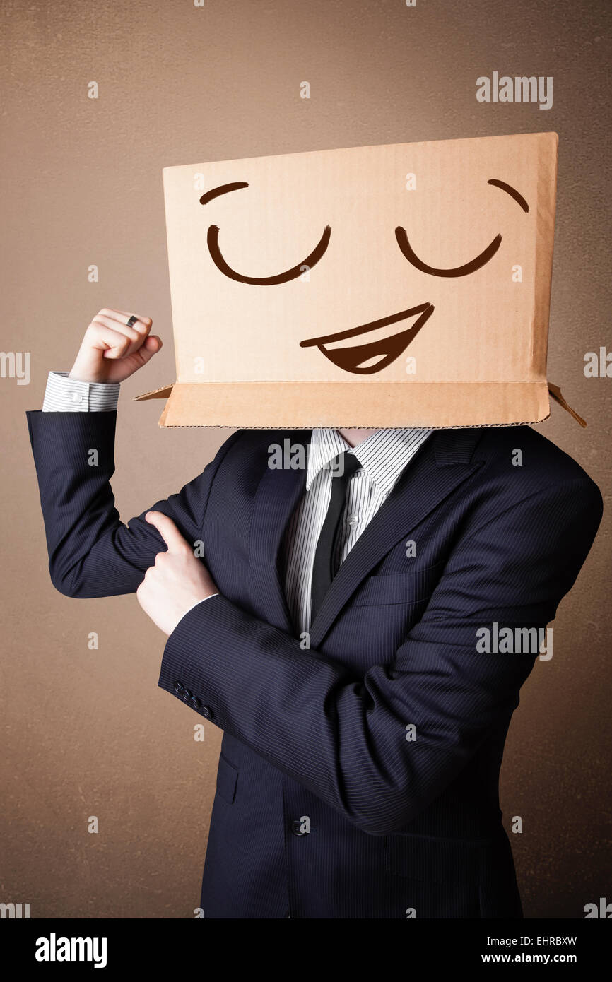 Businessman gesturing with a cardboard box on his head with smiley face ...
