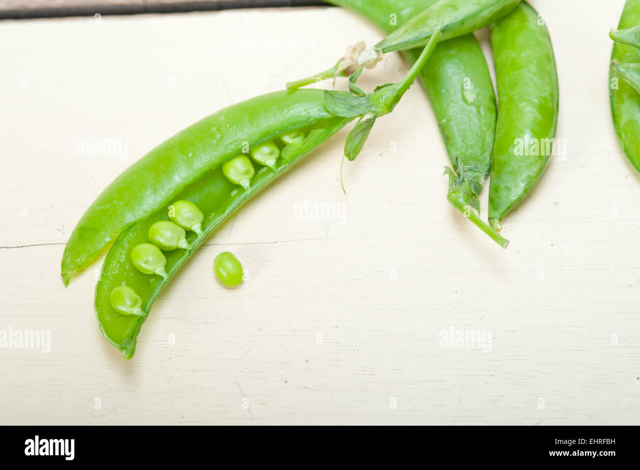 hearthy fresh green peas  over a rustic wood table Stock Photo