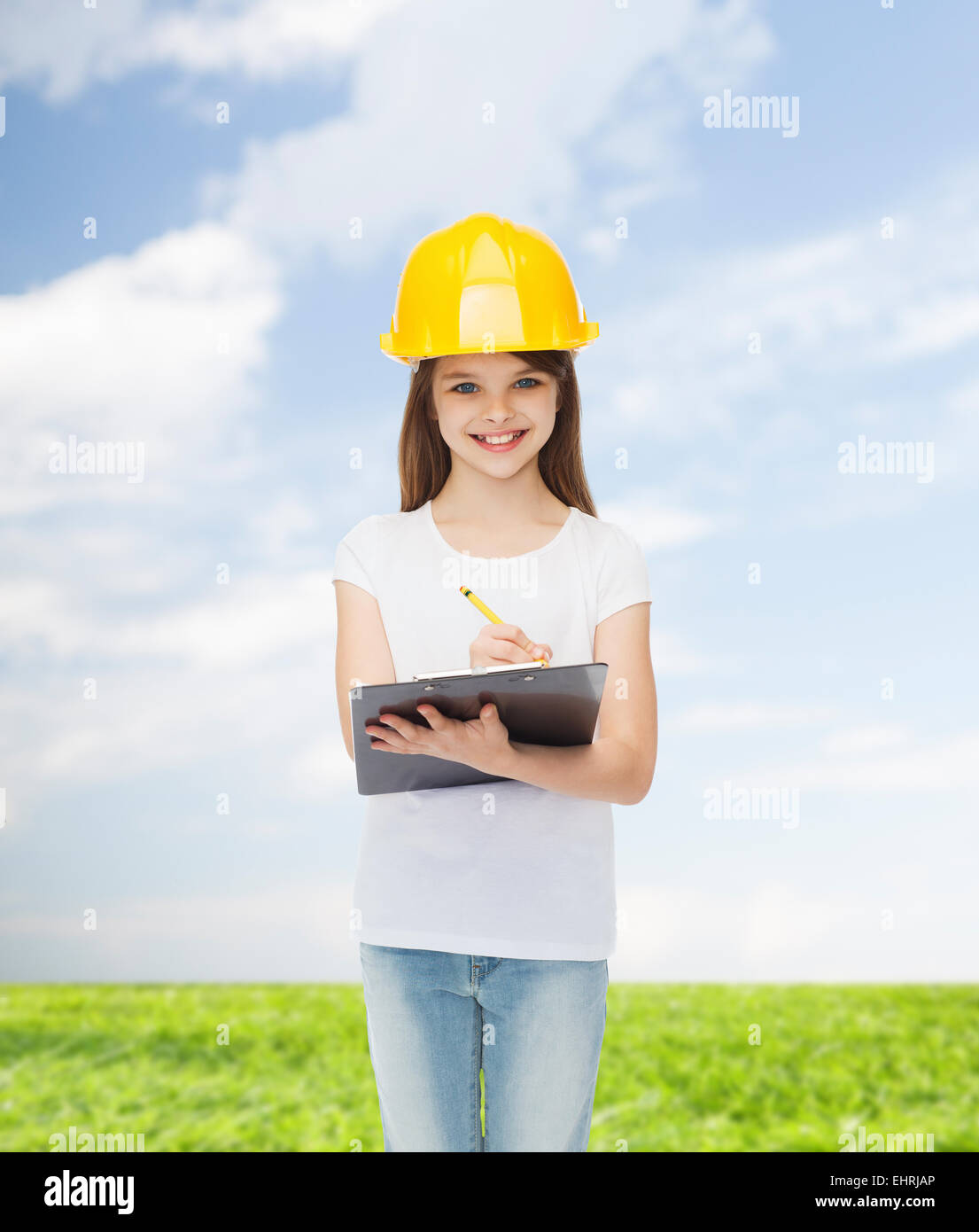smiling little girl in hardhat with clipboard Stock Photo