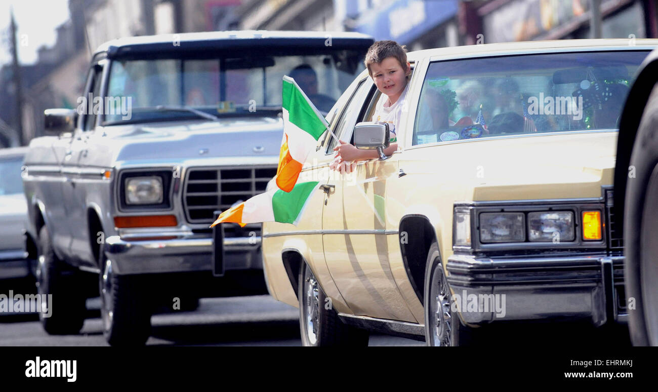 Tullamore, Ireland. 17th March, 2015.  A boy holding an Irish flag while being driven in an Ameriacan car during  the St Patricks Day Parade in Tullamore, Co Offaly, Ireland. Credit:  James Flynn/Alamy Live News Stock Photo