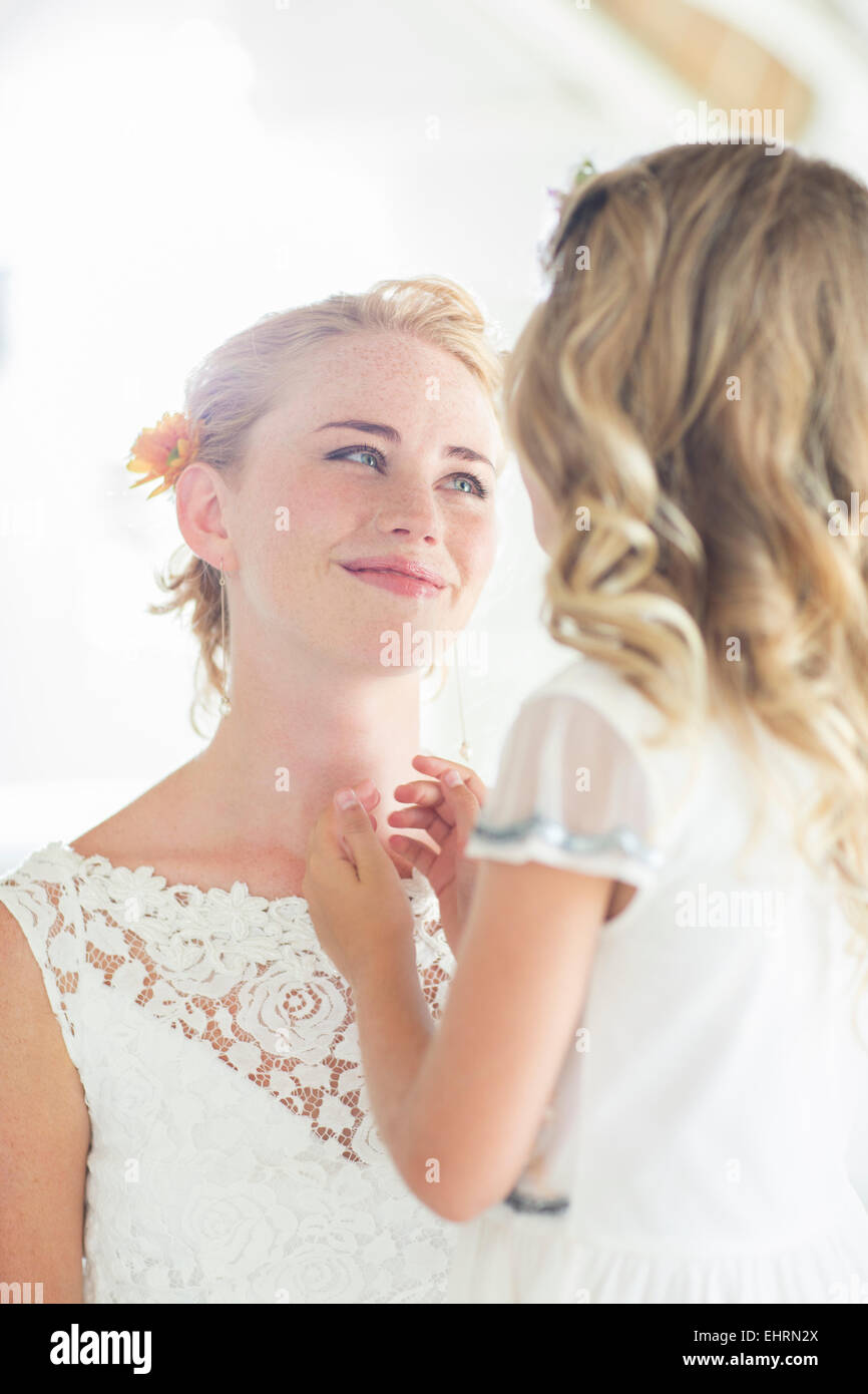 Bride and bridesmaid facing each other and smiling Stock Photo