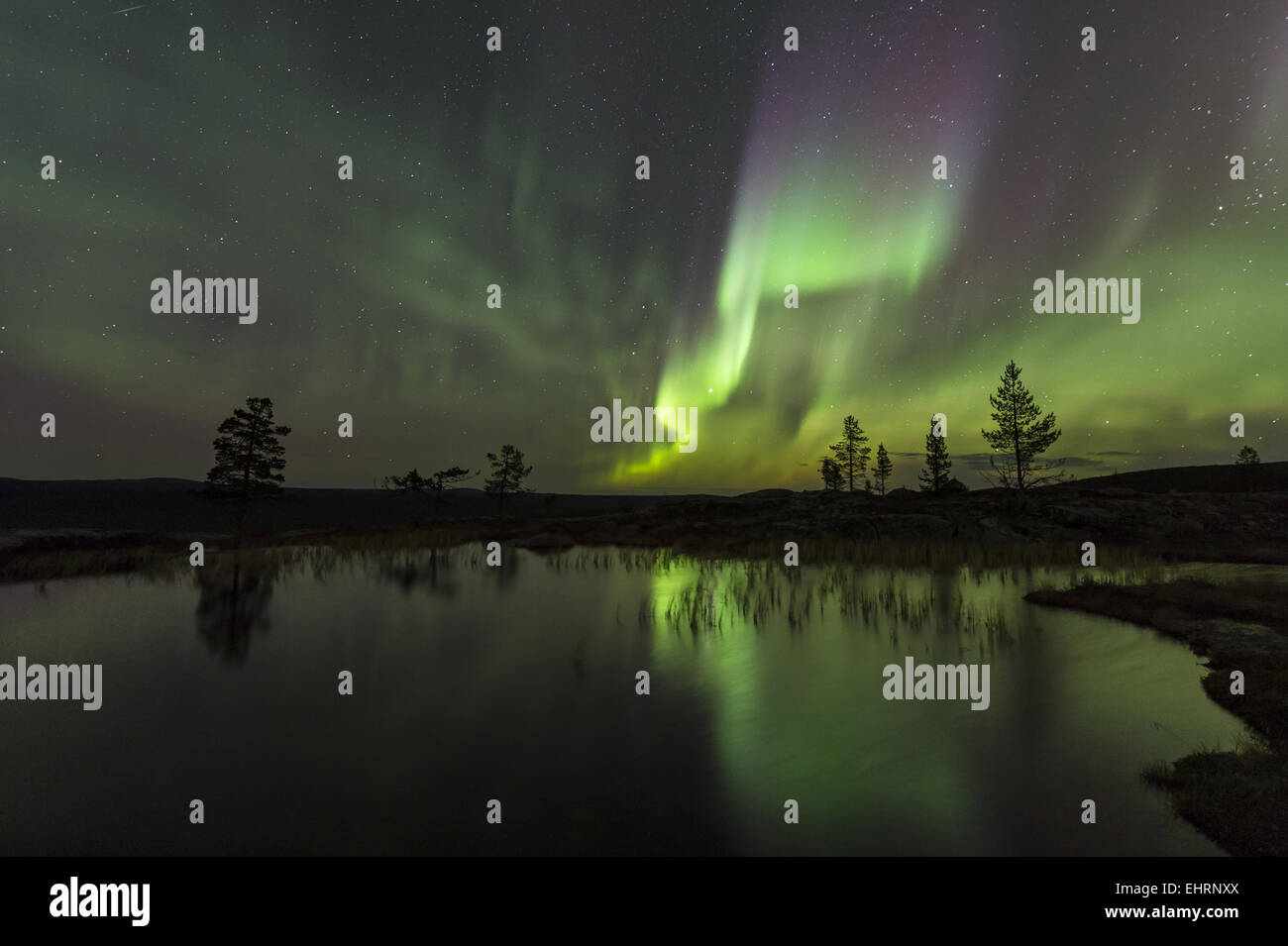 Northern lights reflecting in a lake, Sweden Stock Photo