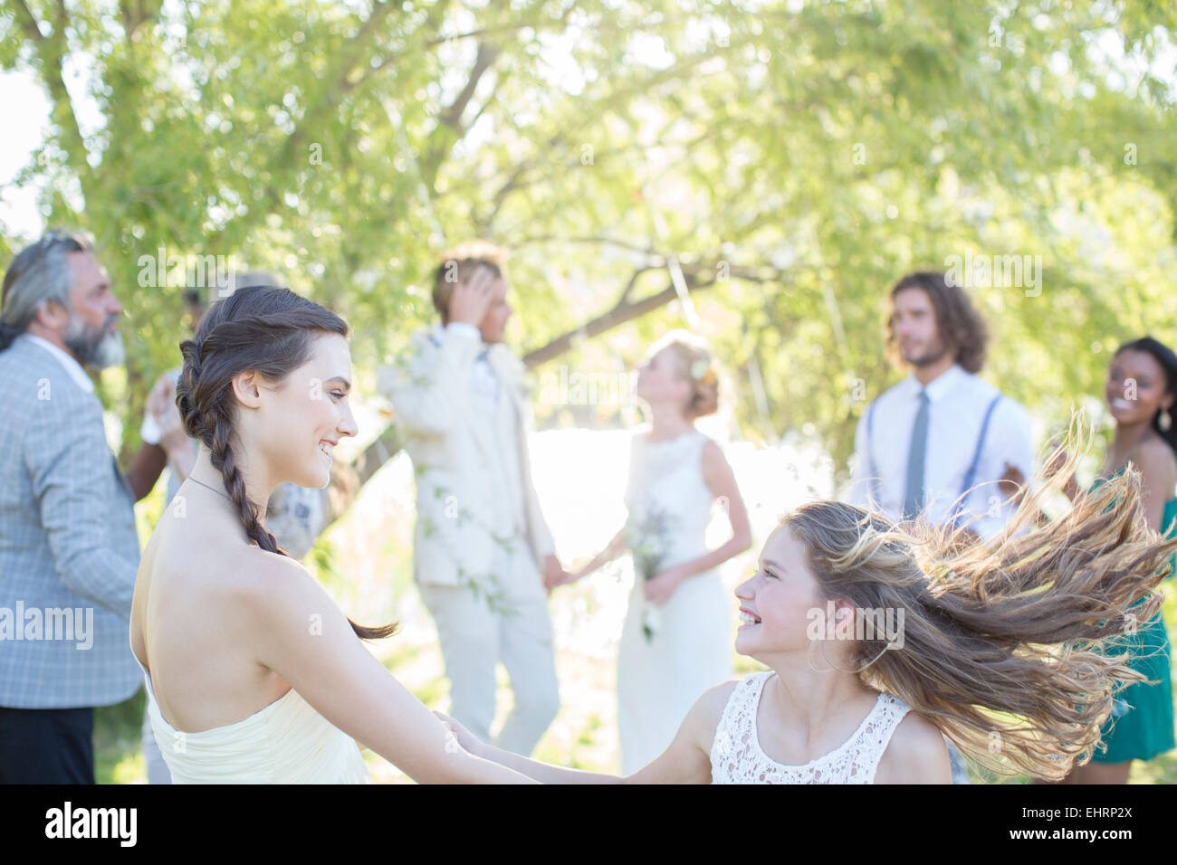 Bridesmaid and girl dancing during wedding reception in domestic garden Stock Photo