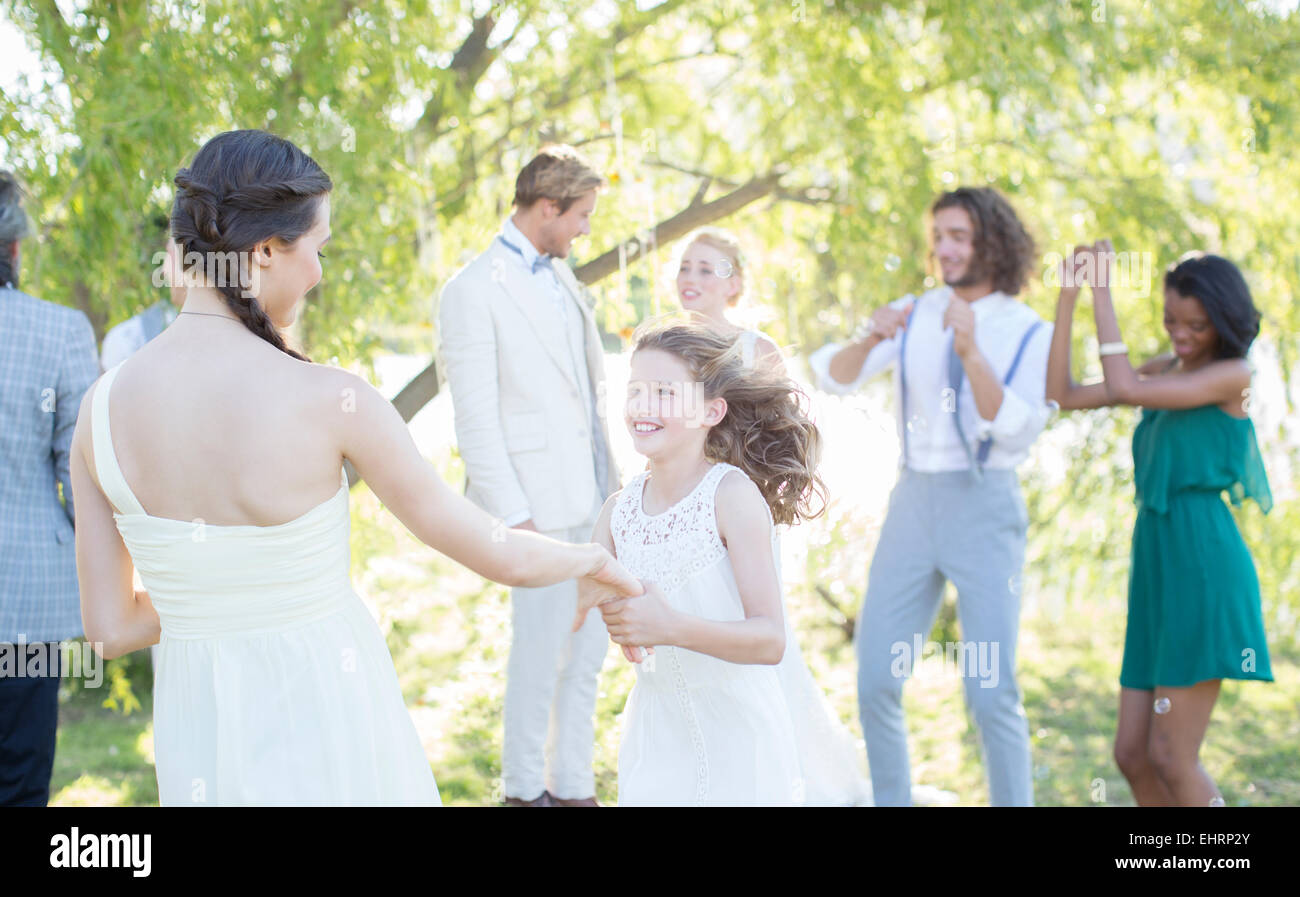 Bridesmaid and girl dancing during wedding reception in domestic garden Stock Photo