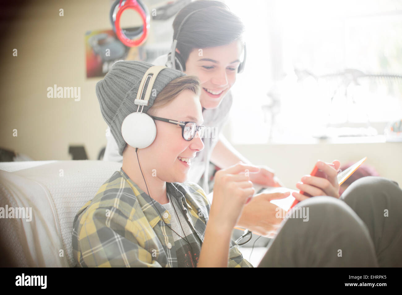 Two teenage boys listening to music on headphones Stock Photo