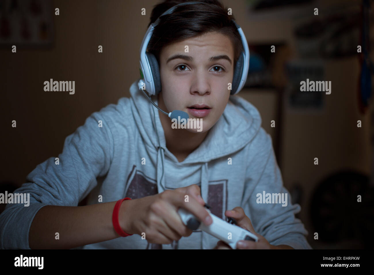 Teenage boy with headset playing video game Stock Photo Alamy