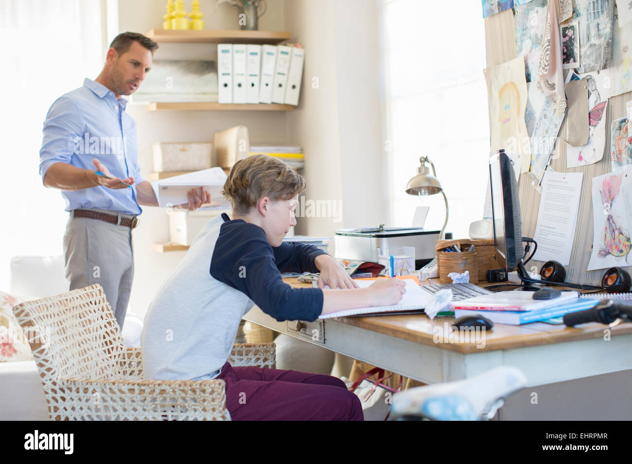 Father helping teenage son doing his homework in room Stock Photo - Alamy