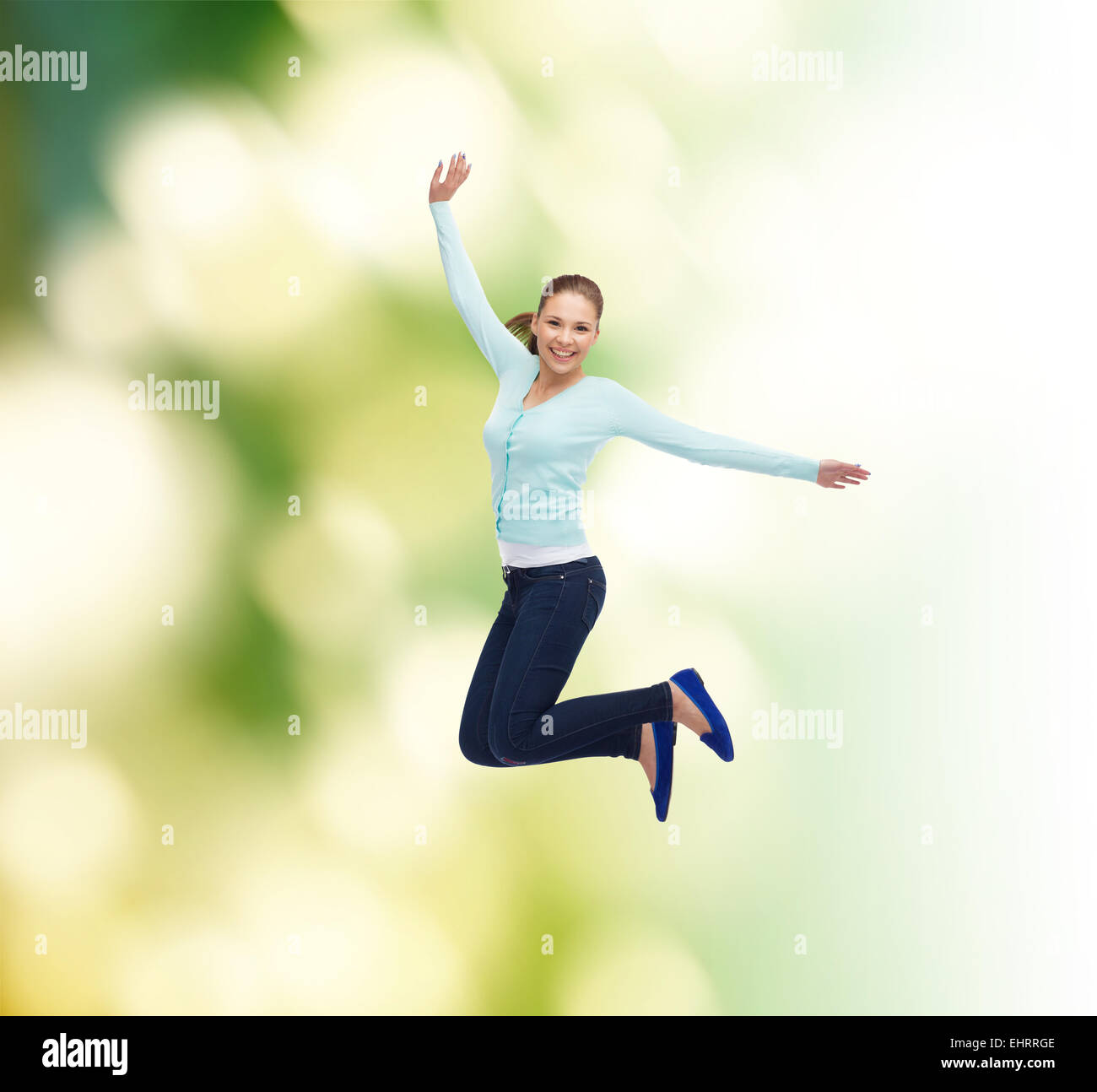 smiling young woman jumping in air Stock Photo - Alamy