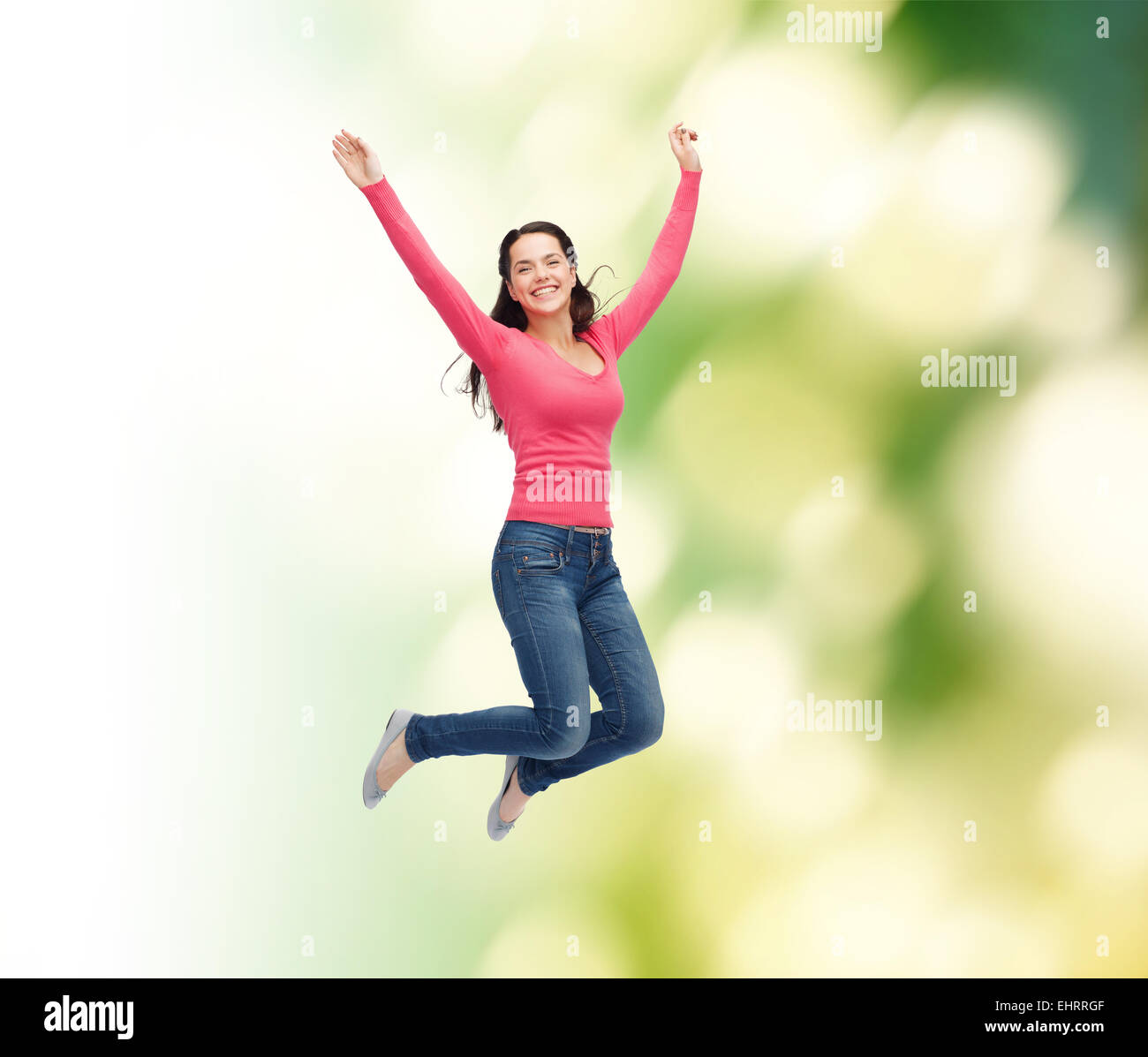 smiling young woman jumping in air Stock Photo - Alamy