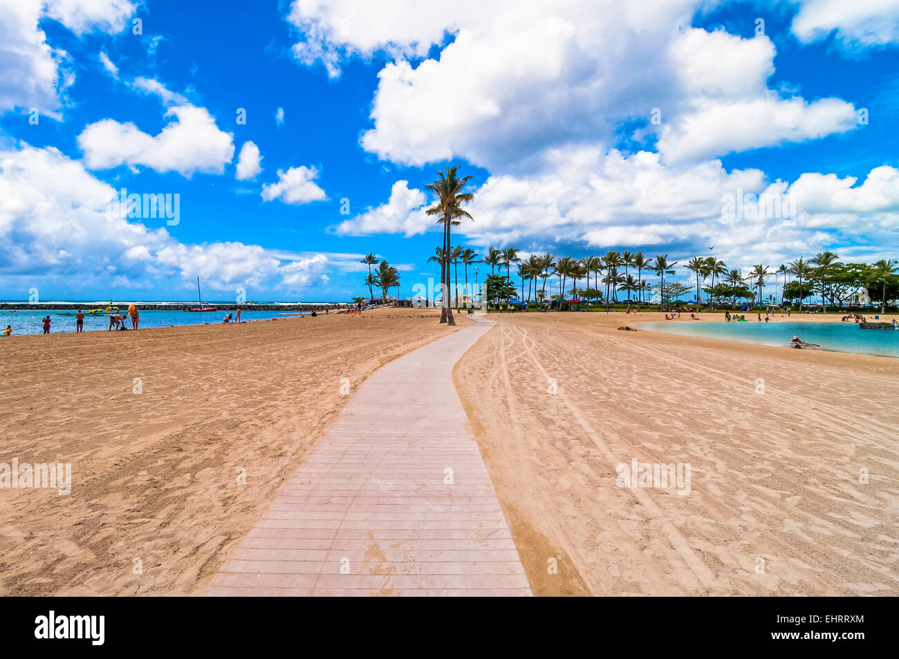 tourists sunbathing and swimming on Waikiki beach in Honolulu, Hawaii