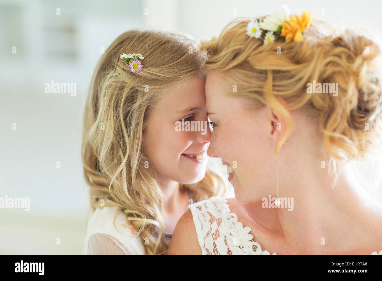 Bride and bridesmaid facing each other smiling Stock Photo