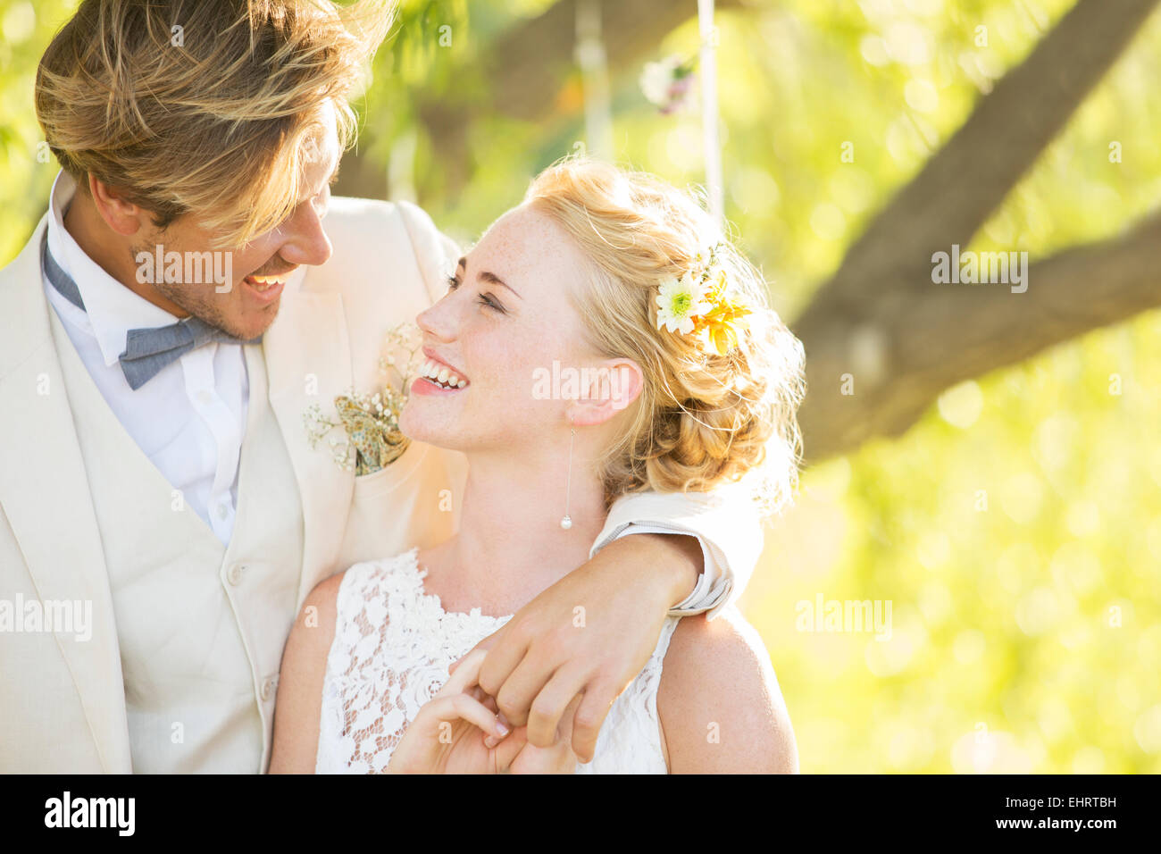 Bridegroom embracing bride in domestic garden Stock Photo