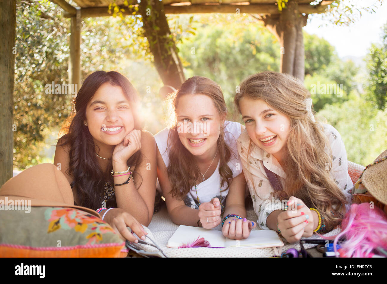 Three teenage girls having fun in tree house in summer Stock Photo