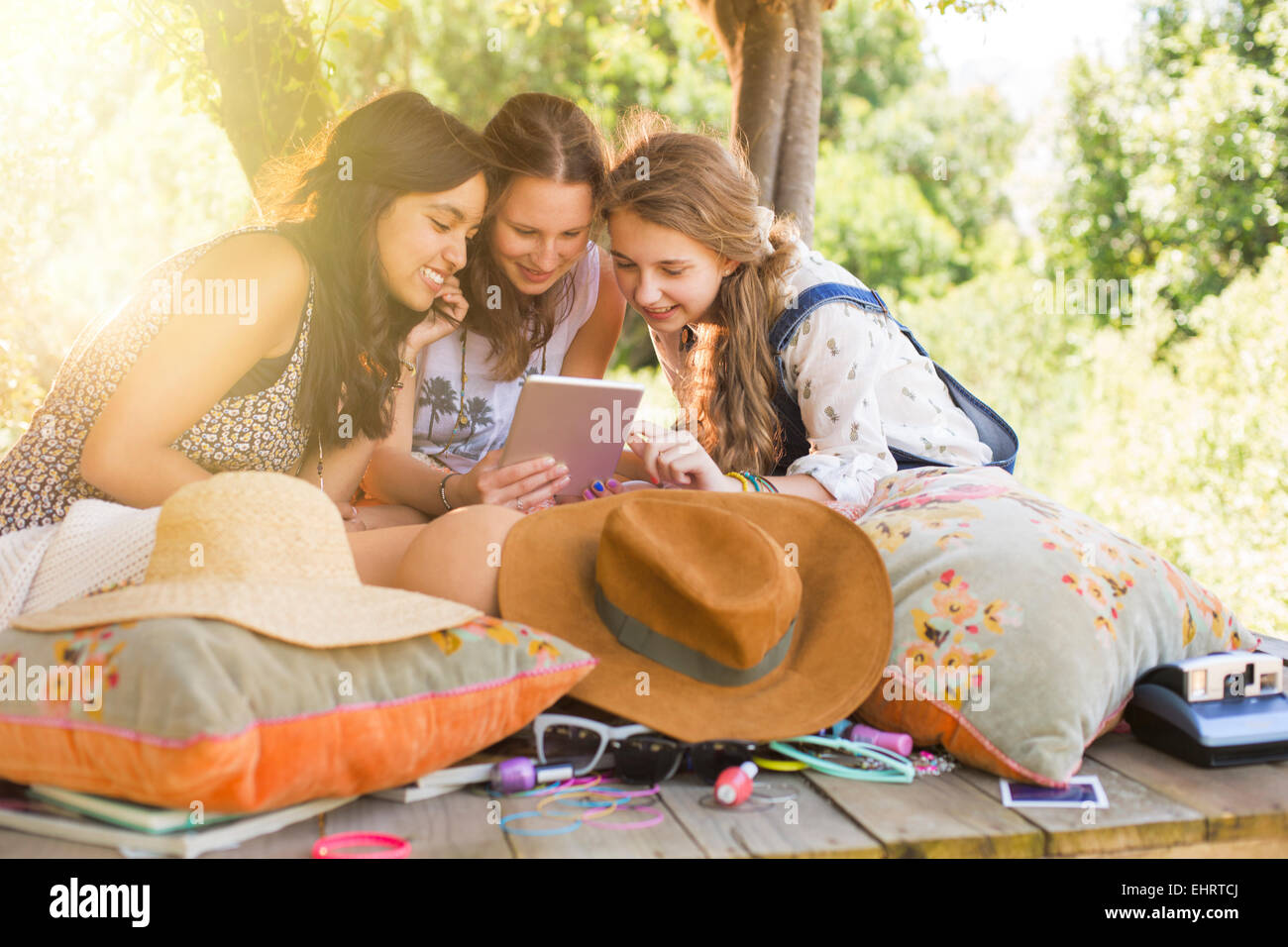 Three teenage girls using digital tablet in tree house Stock Photo