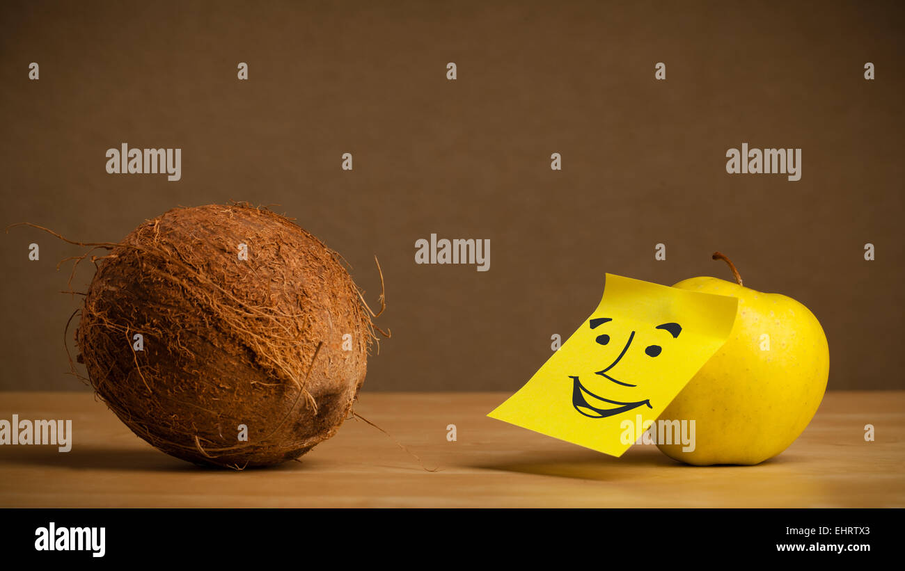 Apple with post-it note smiling at coconut Stock Photo - Alamy
