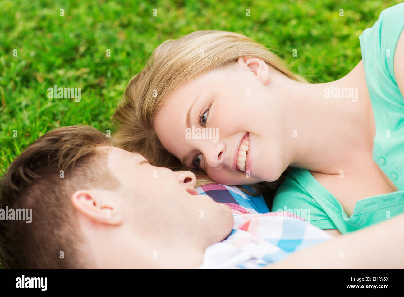 smiling couple lying on grass in park Stock Photo - Alamy