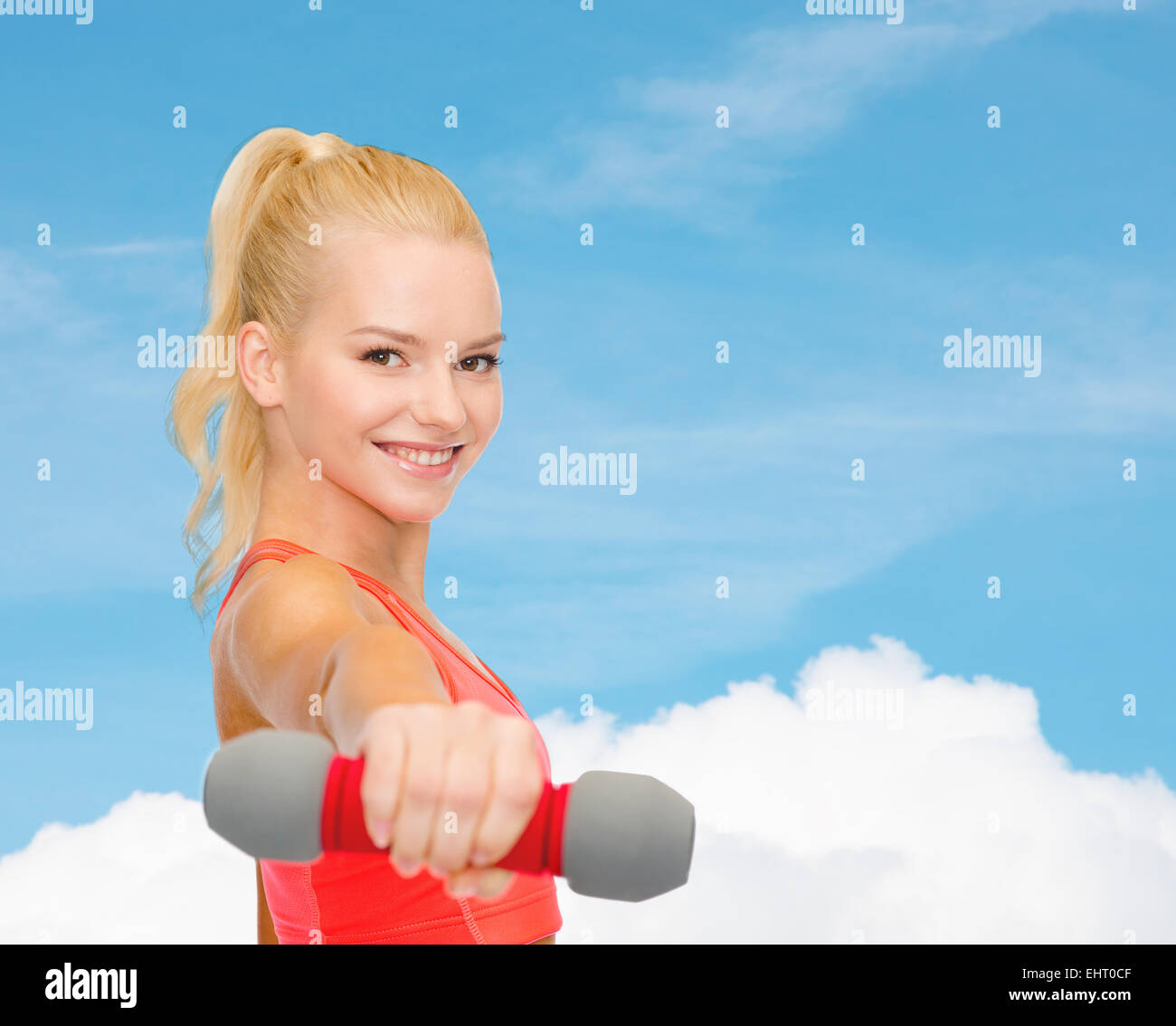 smiling beautiful sporty woman with dumbbell Stock Photo
