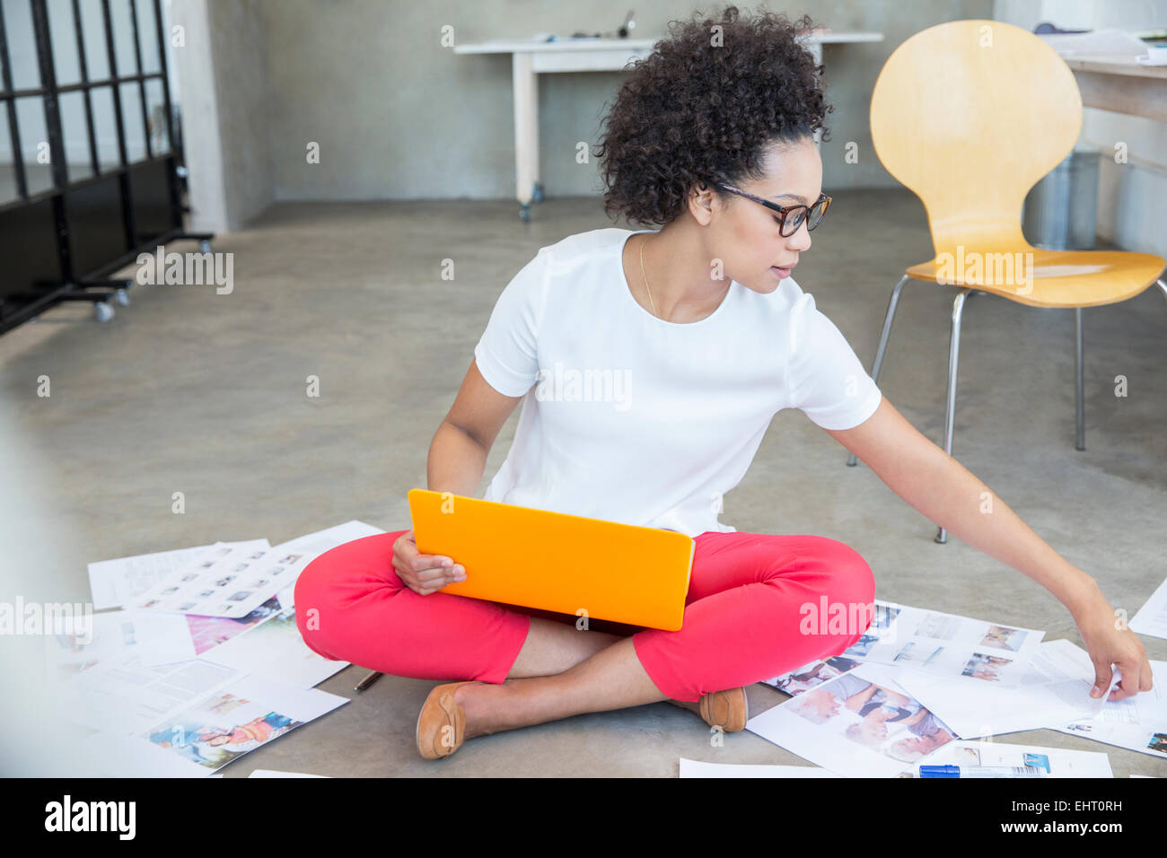 Young woman sitting on floor and working with laptop Stock Photo