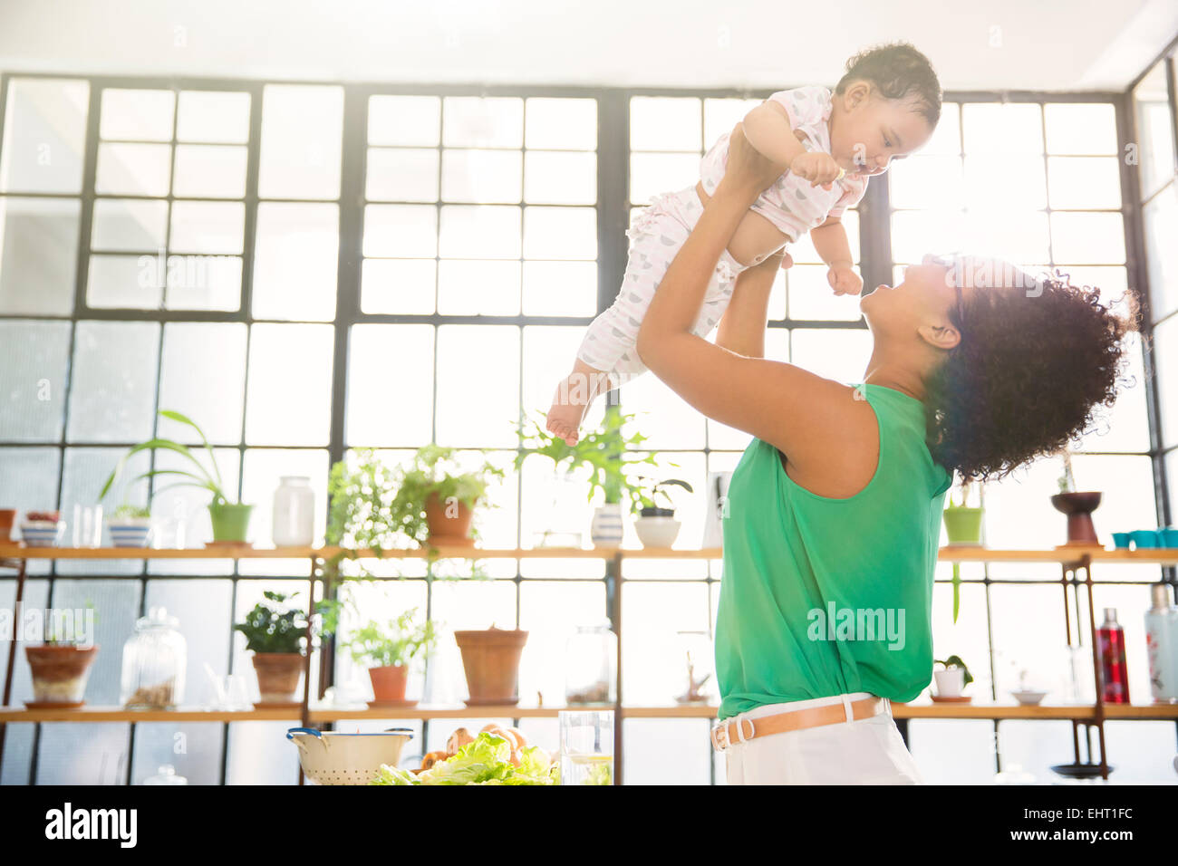 Mother lifting her daughter overhead Stock Photo