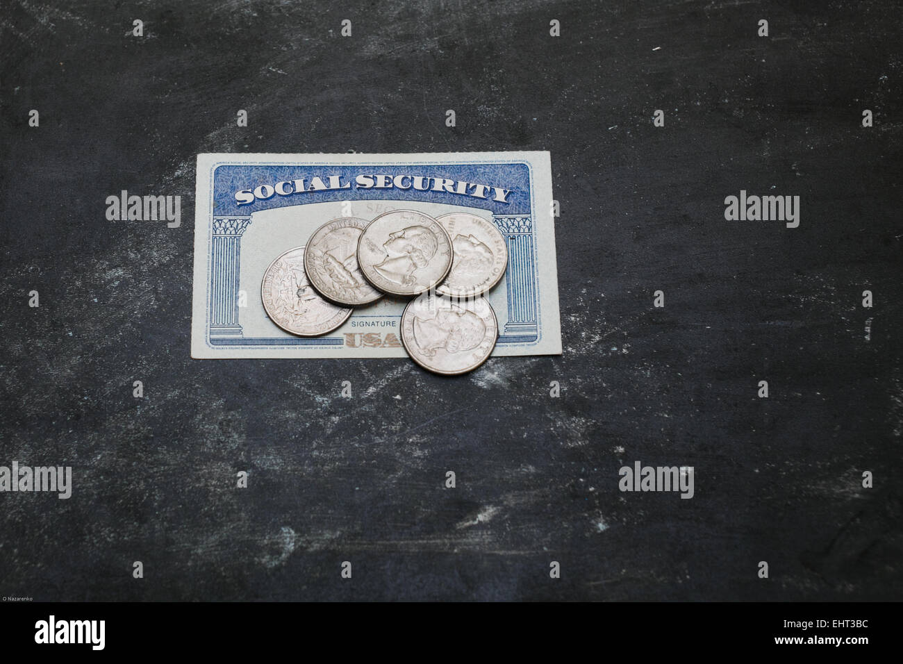 Social security card with coins on it, black background. Stock Photo