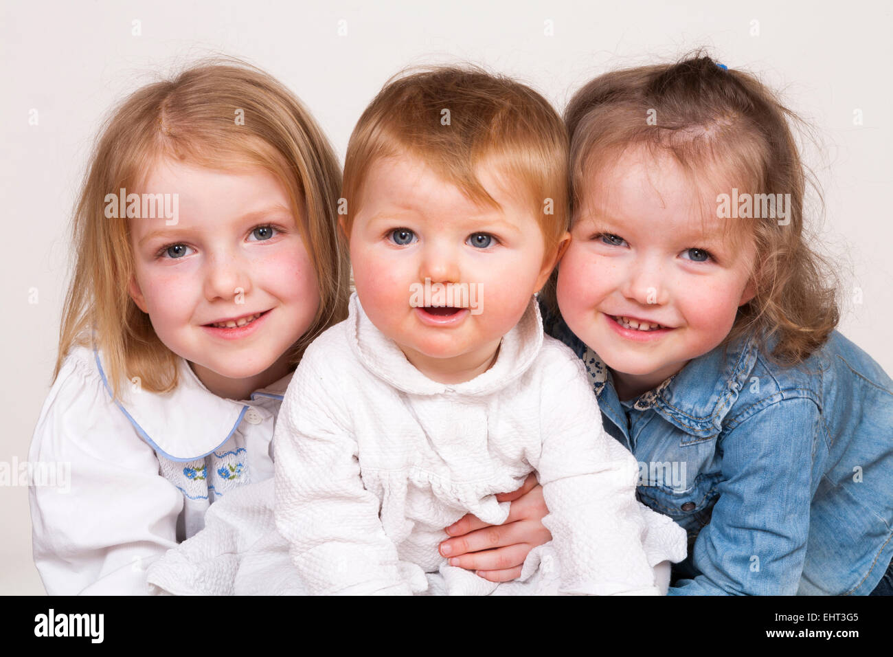 Family group portrait of 3 three young children / kids who are ...