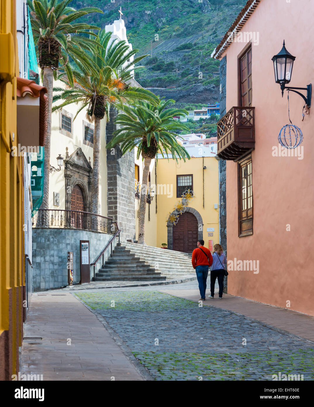 Street in Garachico on the isle of Tenerife in Spain with palm trees and church. Stock Photo