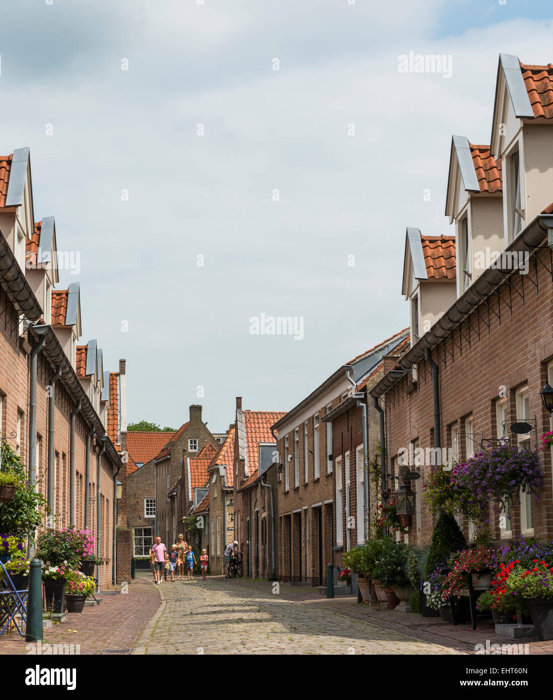Street with tourists, houses and flowers in Heusden. Stock Photo