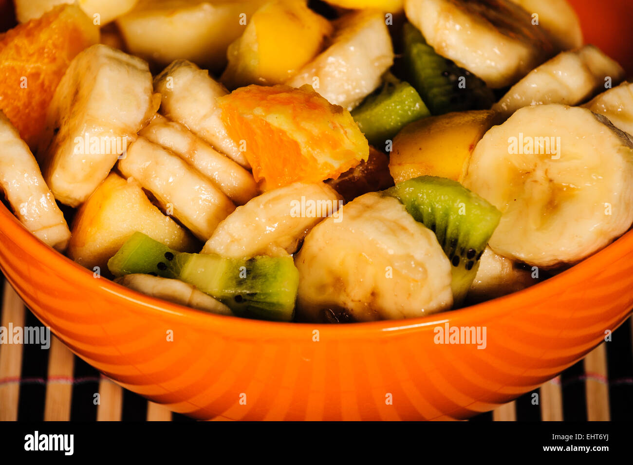 Mixed fruit salad, orange bowl, fresh healthy diet, closeup Stock Photo
