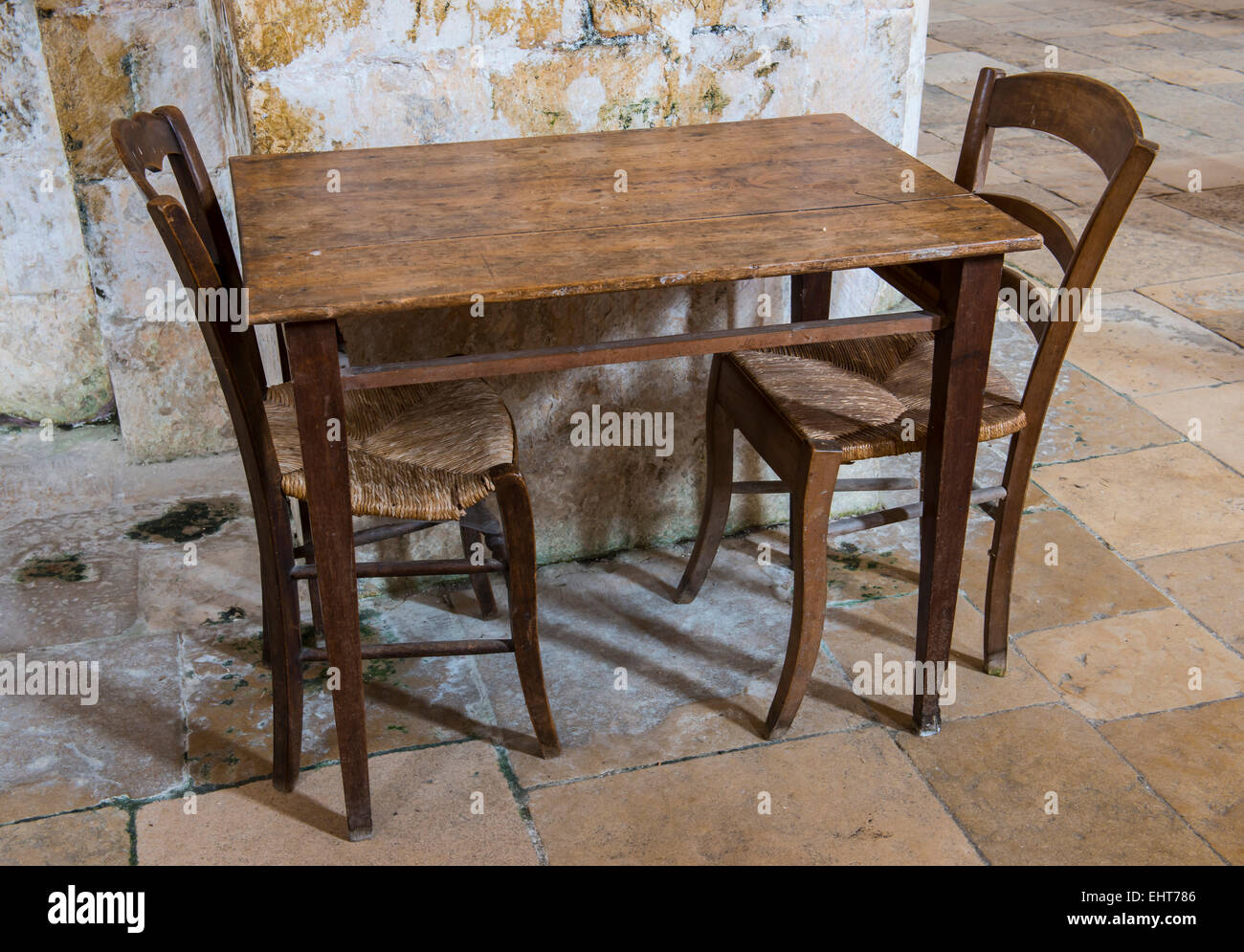 Wooden old table and two wooden chairs on a floor of old tiles Stock Photo  - Alamy