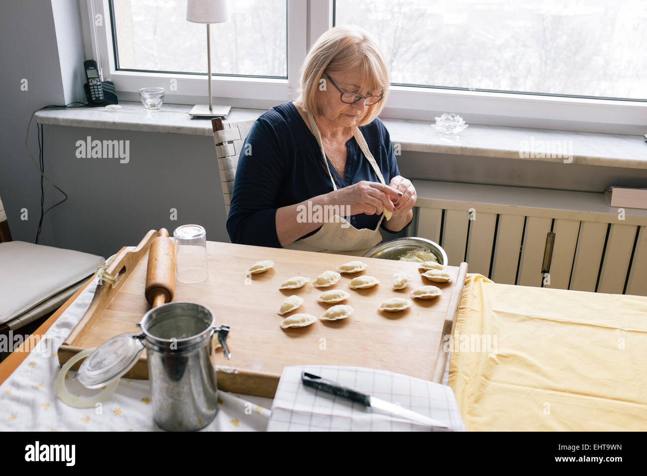 An old woman making traditional pierogi meal at home, Poland Stock Photo