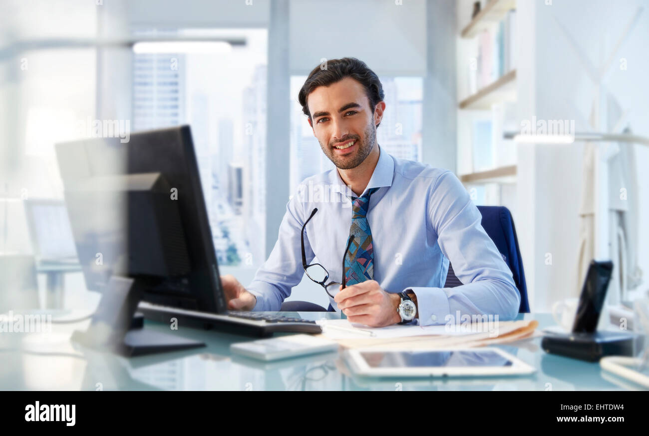 Portrait Of Man Sitting At His Desk In Office Stock Photo