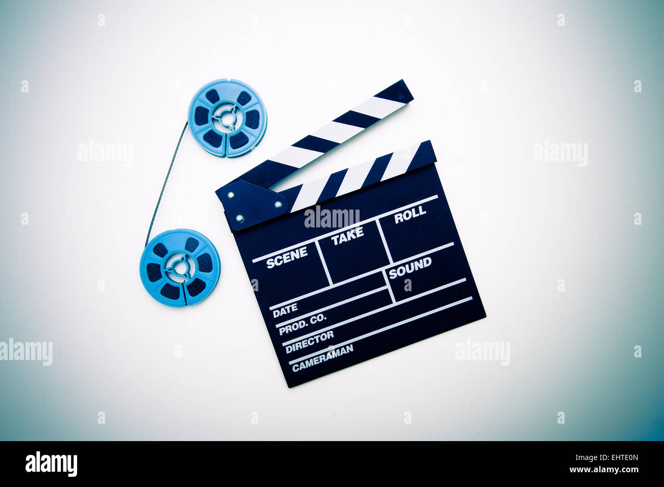 Two vintage 8mm blue reels connected with film and clapper board vintage color style Stock Photo