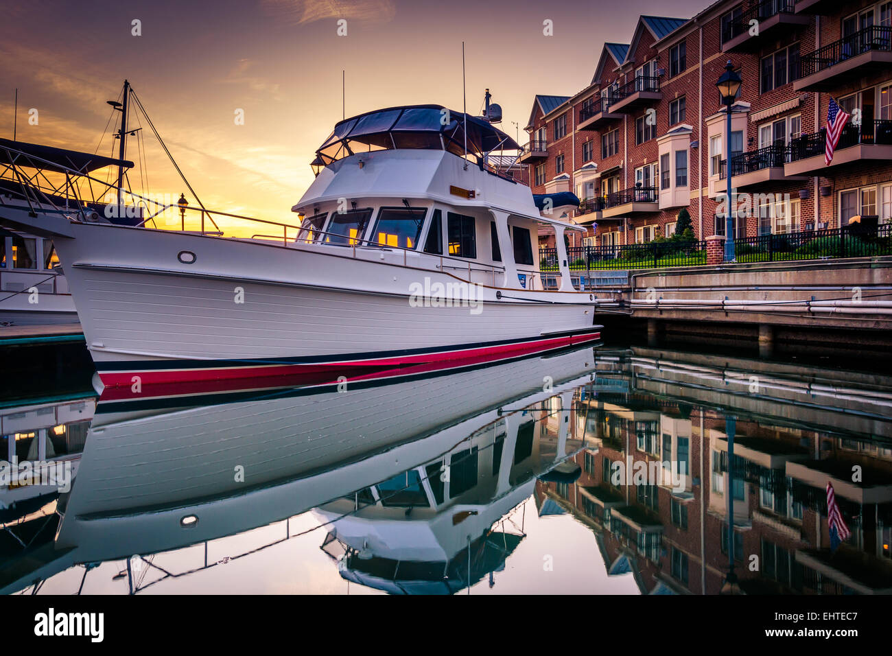 Boat and waterfront condominiums reflecting in the water at sunset in
