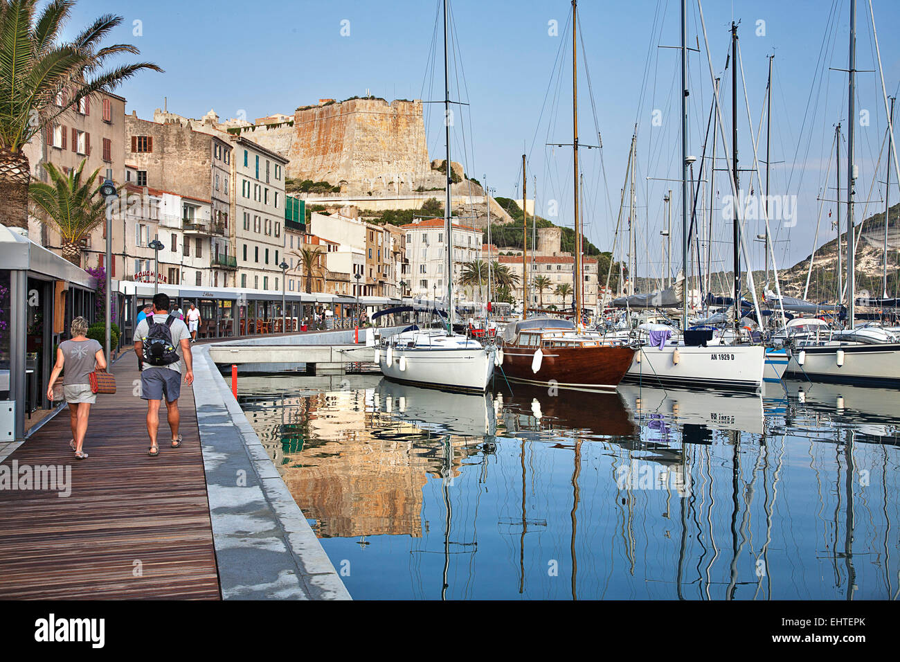 The quay at Bonifacio harbor is lined with boats, visitors and hotels. Stock Photo