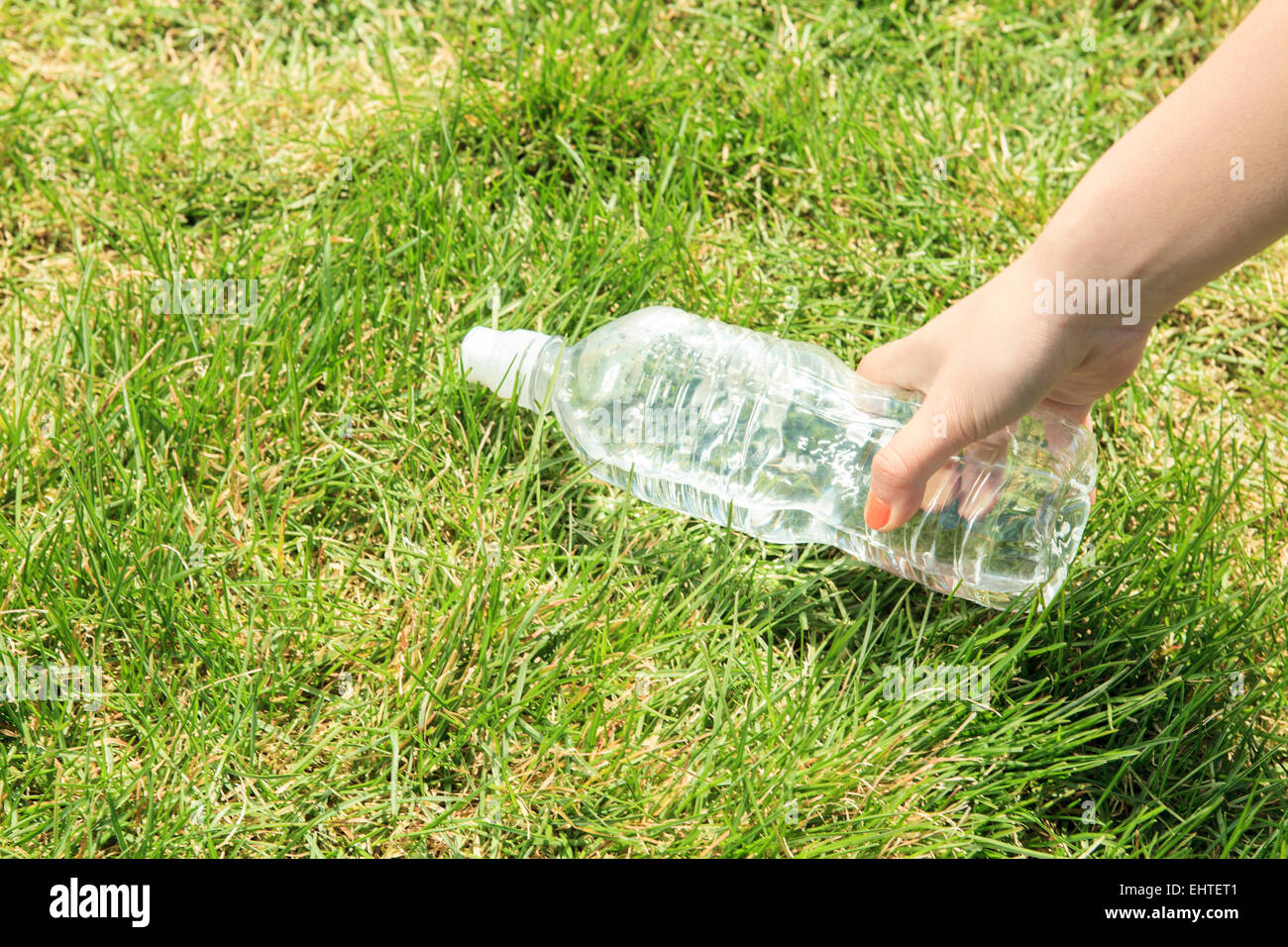 hand bottle water grass Stock Photo - Alamy