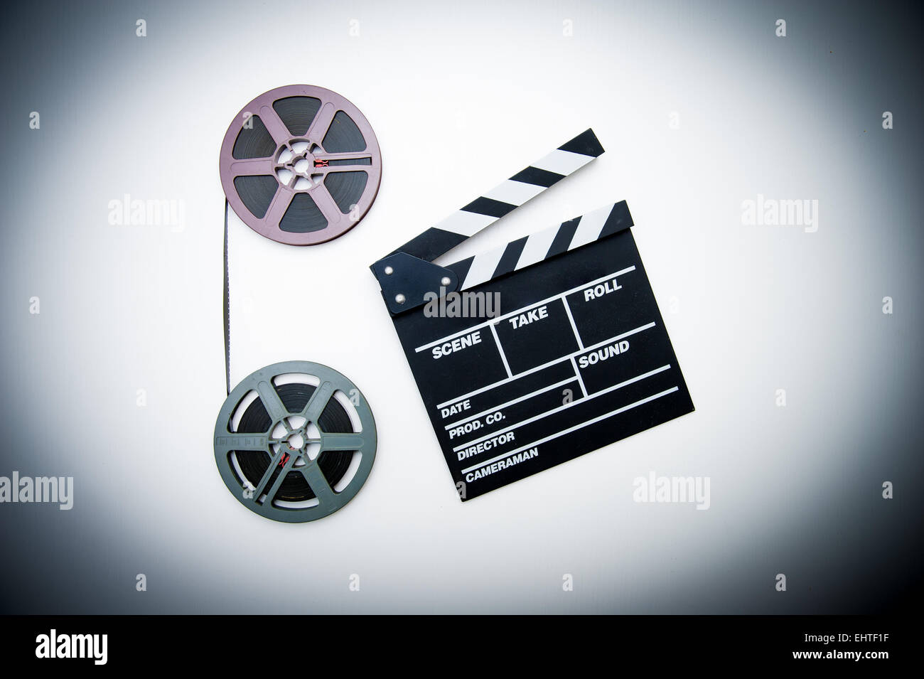 Two 8mm purple and grey movie reels vertically connected with film and clapper board in vintage color effect Stock Photo