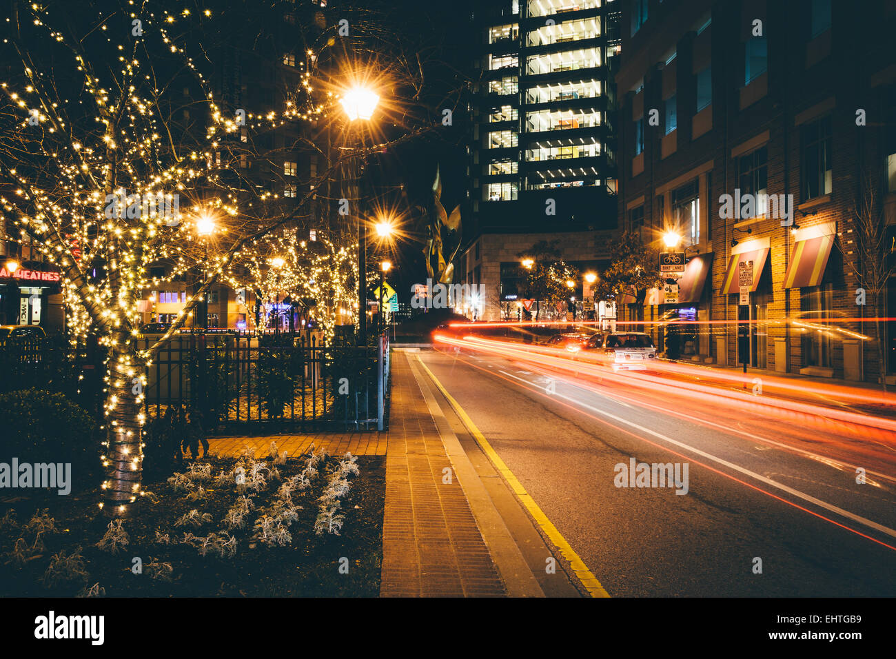 Christmas lights on trees and traffic along a street in Harbor East, Baltimore, Maryland. Stock Photo