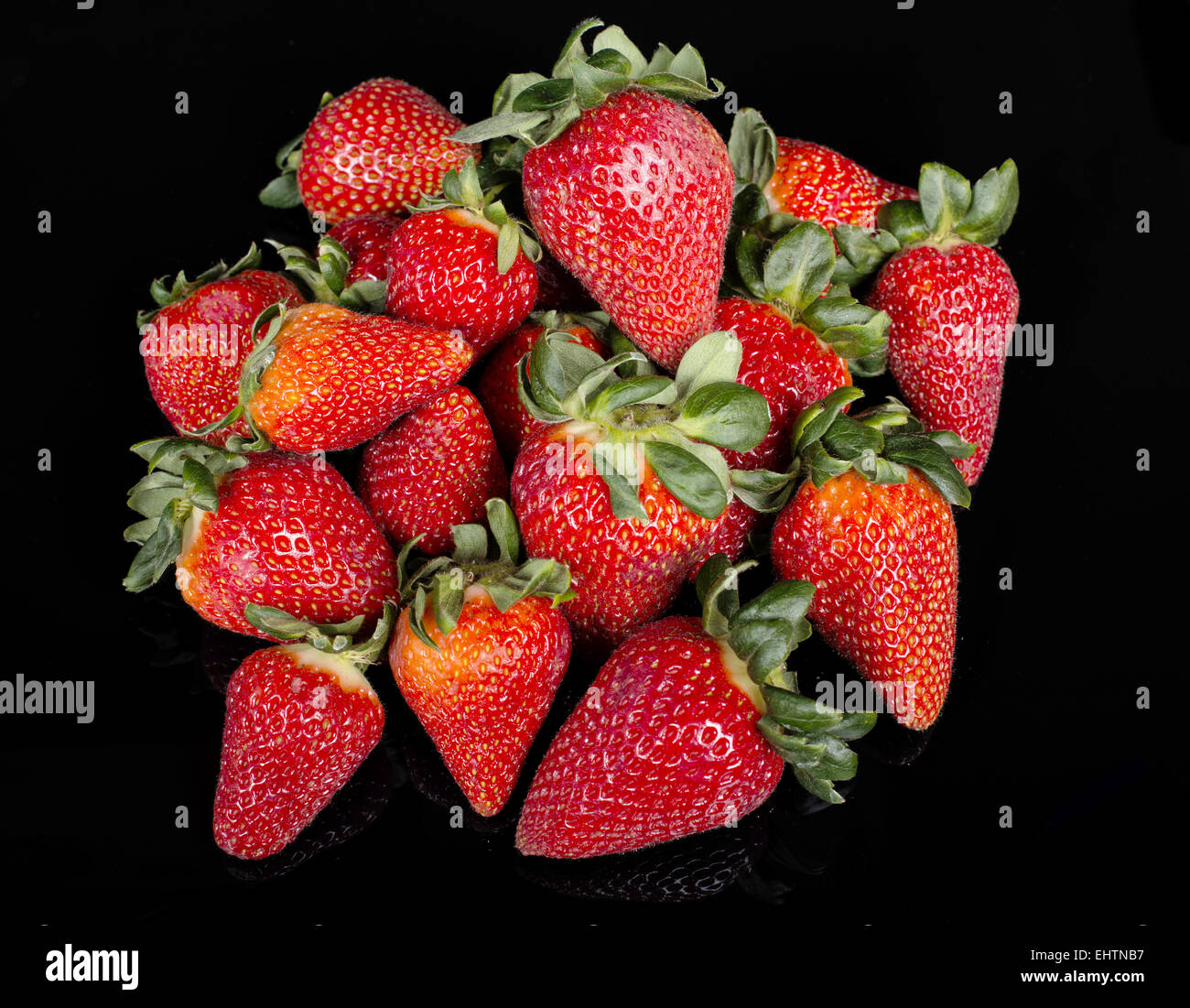 pile of strawberries on black background Stock Photo - Alamy